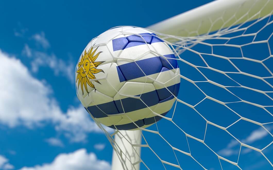 Uruguay flag and soccer ball in goal net.
